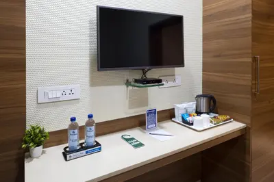 a room with a counter with a television on a wall at Ananyas Nest in Coimbatore
