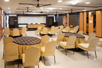 a conference room with tables and chairs and a projection screen at Ananyas Nest in Coimbatore