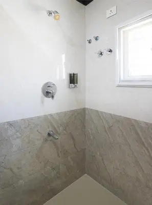 a bathroom with a shower with a sink at Ananyas Nest in Coimbatore