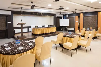 a conference room with tables and chairs and a podium at Ananyas Nest in Coimbatore