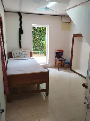 a bedroom with a bed and a window at Bethany stay in Ooty