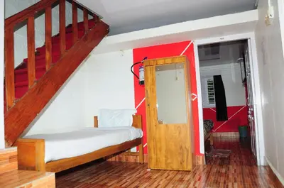 a bedroom with a bed and a stair case at Bethany stay in Ooty