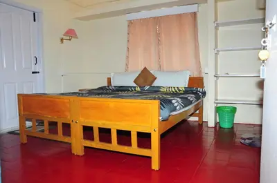 a bedroom with a wooden bed in a room at Bethany stay in Ooty