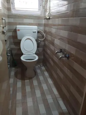 a bathroom with a toilet and a window at Bethany stay in Ooty
