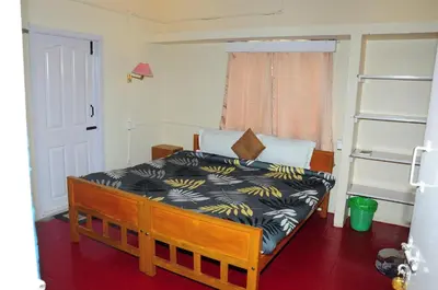 a bedroom with a bed with a black and yellow blanket at Bethany stay in Ooty