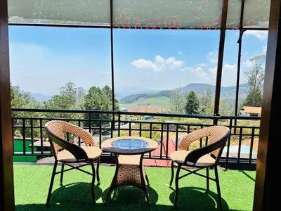 a table and chairs on a balcony with a view at Sunrise Peak View in Lovedale