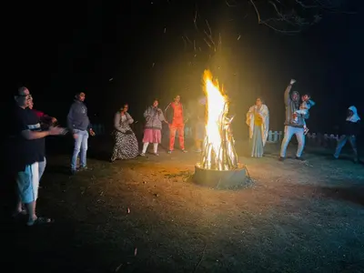 a group of people standing around a large fire at Sunrise Peak View in Lovedale