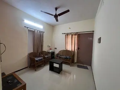 a living room with a ceiling fan and chairs at SHI's 2BHK home in Coimbatore near Sai Baba Colony, Ganga C Hospital, Women's care in Coimbatore