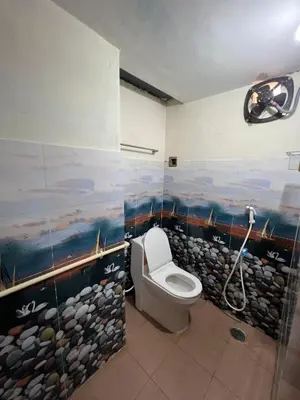 a bathroom with a toilet and a painting on the wall at SHI's 2BHK home in Coimbatore near Sai Baba Colony, Ganga C Hospital, Women's care in Coimbatore