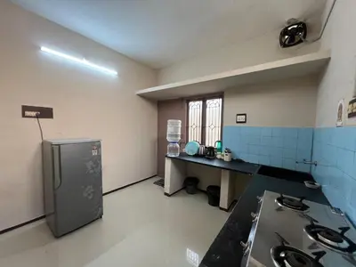 an empty kitchen with a sink and a refrigerator at SHI's 2BHK home in Coimbatore near Sai Baba Colony, Ganga C Hospital, Women's care in Coimbatore