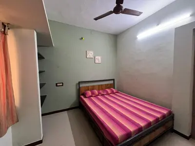 a bedroom with a bed with a pink blanket at SHI's 2BHK home in Coimbatore near Sai Baba Colony, Ganga C Hospital, Women's care in Coimbatore