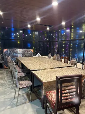a large table and chairs in a room with wine bottles at GV Royal Residency Vattavada in Vattavada