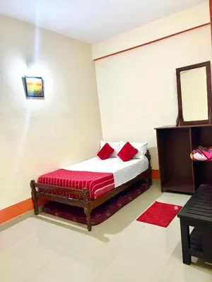 a bedroom with a bed with red pillows on it at GV Royal Residency Vattavada in Vattavada