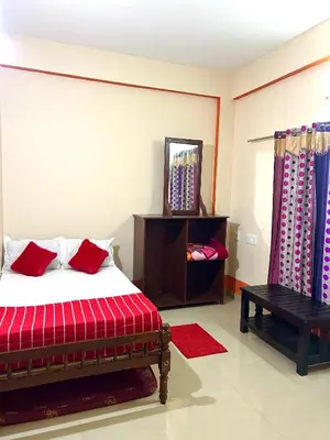 a bedroom with a bed and a mirror and a table at GV Royal Residency Vattavada in Vattavada