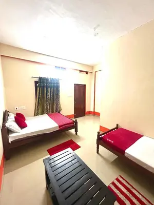 a room with two beds and a couch in it at GV Royal Residency Vattavada in Vattavada