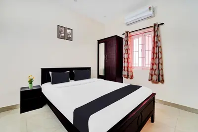 a bedroom with a large bed and a window at Super Hotel O Viswapuram in Coimbatore
