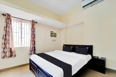 a bedroom with a bed and a window at Super Hotel O Viswapuram in Coimbatore