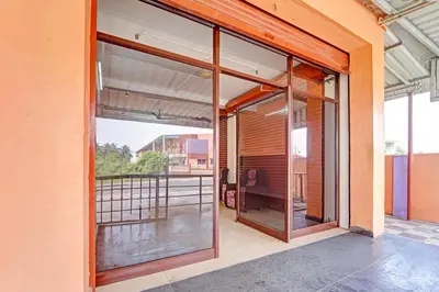 an open glass door of a building with a balcony at Super Hotel O Viswapuram in Coimbatore
