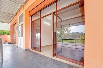 a large glass door in a house with a balcony at Super Hotel O Viswapuram in Coimbatore