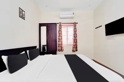 a bedroom with a large bed and a window at Super Hotel O Viswapuram in Coimbatore