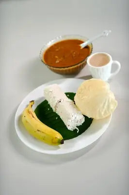 a plate of food with a banana and dip at Ayurnest Pool Resort Wayanad in Batheri