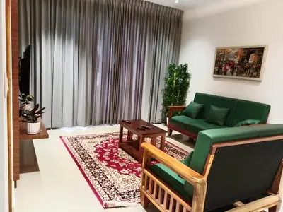 a living room with a green couch and a table at Seashells Pentagon Calicutbeach in Kozhikode