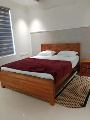 a bedroom with a large bed with a wooden headboard at Seashells Pentagon Calicutbeach in Kozhikode