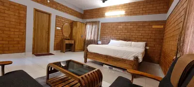 a bedroom with a bed and a table in a room at KK Selfie Point Resort in Coimbatore