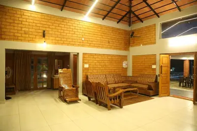 a living room with a couch and rocking chairs at KK Selfie Point Resort in Coimbatore