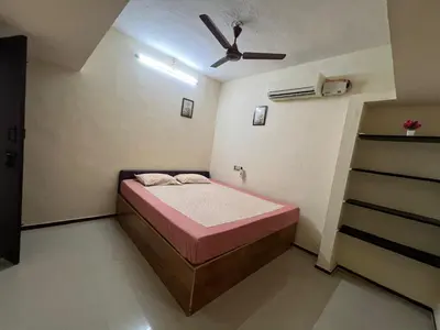 a small bedroom with a bed and a ceiling fan at SHI's 2bhk Near Ganga Hospital in Coimbatore