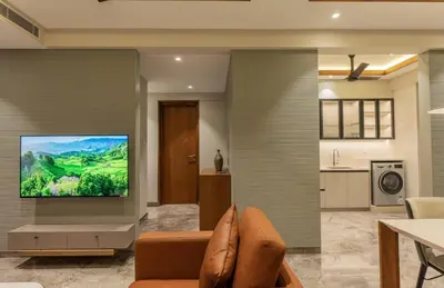 a living room with a flat screen tv on a wall at Seashell Apartments in Kozhikode