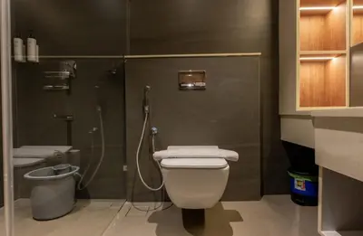 a bathroom with a shower and a toilet and a sink at Seashell Apartments in Kozhikode