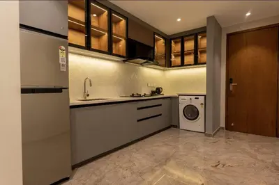a kitchen with a sink and a washing machine at Seashell Apartments in Kozhikode
