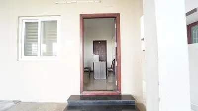 a glass door on a white building with a table at Codissia In Nini Residency in Coimbatore