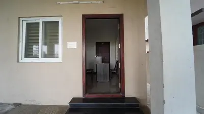 a door of a house with a table and a window at Codissia In Nini Residency in Coimbatore