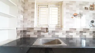 a kitchen with a sink in a counter top at Codissia In Nini Residency in Coimbatore