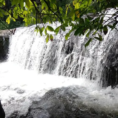 a waterfall in the middle of a river at Holy Village Homestay in Neriyamangalam
