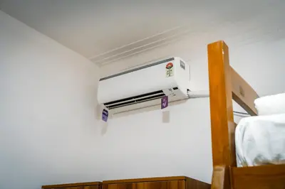 a room with a heater on the wall next to a bed at Leo Vishroam in Mysore