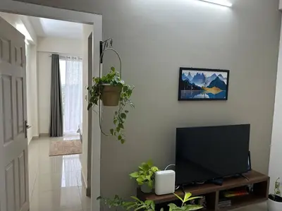 a living room with a flat screen tv and plants at Memmsta Blooming Bird Guruvayur in Guruvāyūr