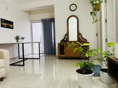 a living room with a mirror and a table with plants at Memmsta Blooming Bird Guruvayur in Guruvāyūr