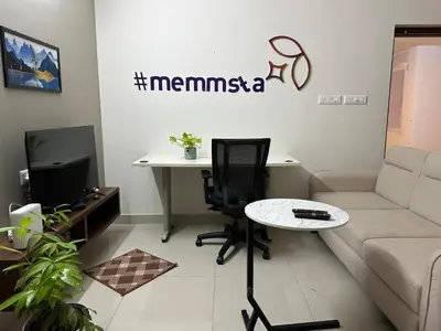 a living room with a couch and a table at Memmsta Blooming Bird Guruvayur in Guruvāyūr