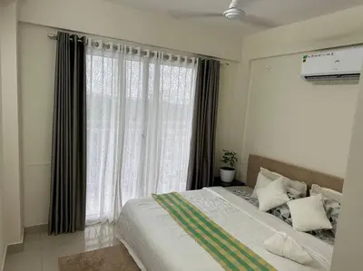 a bedroom with a bed and a large window at Memmsta Blooming Bird Guruvayur in Guruvāyūr