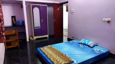 a bedroom with a blue bed and a purple door at NJM Villa in Coimbatore