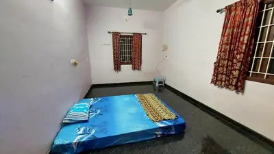 a room with a bed in the corner of a room at NJM Villa in Coimbatore