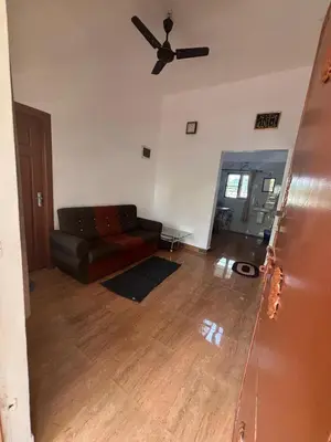 a living room with a couch and a ceiling fan at Nature's View Service Villa in Vythiri