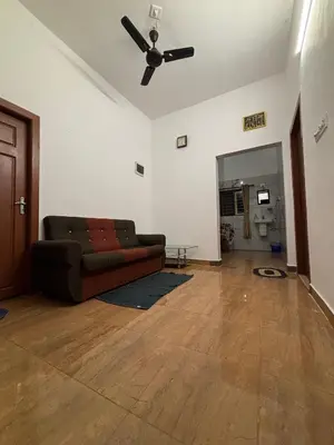 a living room with a couch and a ceiling fan at Nature's View Service Villa in Vythiri