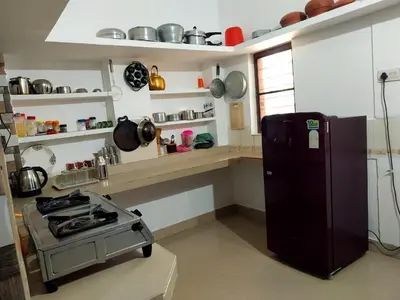 a kitchen with a stove and a refrigerator at Nature's View Service Villa in Vythiri