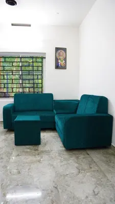 a living room with two green couches in a room at Prakruthi Home stay in Kanjikode