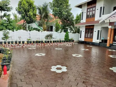 a flooded street with a house and a white fence at Roneys Villa in Wayanad