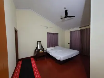 a bedroom with a bed and a tv on the ceiling at The Forest Temple in Kaniyāmbetta
